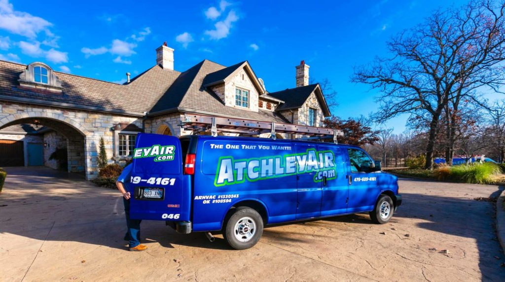 Atchley Air service van parked in front of a large stone home.