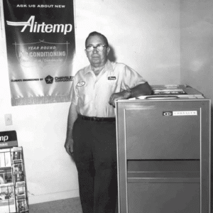 Black-and-white photo of Atchley Air founder standing next to a furnace.